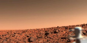 A UTOPIAN BRIGHT SUMMER AFTERNOON ON MARS--Looking south from Viking 2 on September 6, the orange-red surface of the nearly level plain upon which the spacecraft sits is seen strewn with rocks as large as three feet across. Many of these rocks are porous and sponge-like, similar to some of Earth's volcanic rocks. Other rocks are coarse-grained such as the large rock at lower left. Between the rocks, the surface is blanketed with fine-grained material that, in places, is piled into small drifts and banked against some of the larger blocks. The cylindrical mast with the orange cable is the low-gain antenna used to receive commands from Earth.